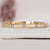 Yellow gold band featuring round diamonds.
