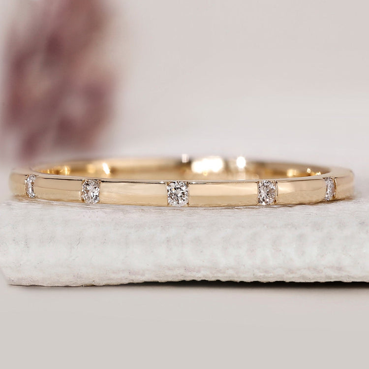 Yellow gold band featuring round diamonds.
