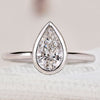 Pear cut diamond engagement ring with bezel setting.
