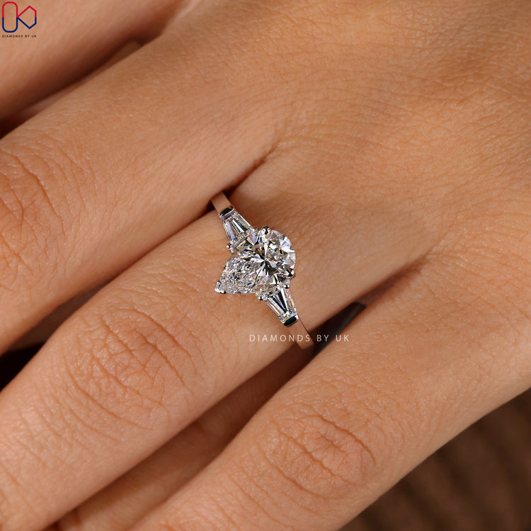 Handmade jewelry ring with teardrop diamond and side stones.
