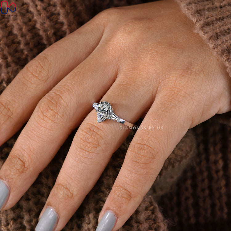 IGI certified pear shaped ring with tapered baguettes.
