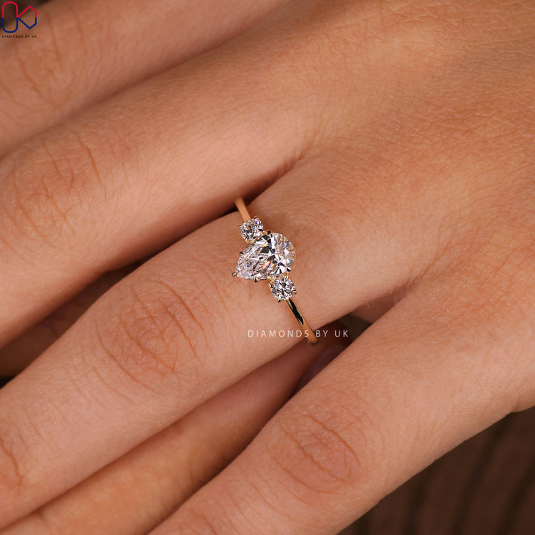 Round diamond side stone enhancing the central gem for extra sparkle.

