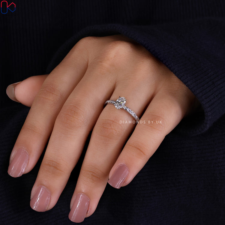 Hidden halo engagement ring with oval center stone.