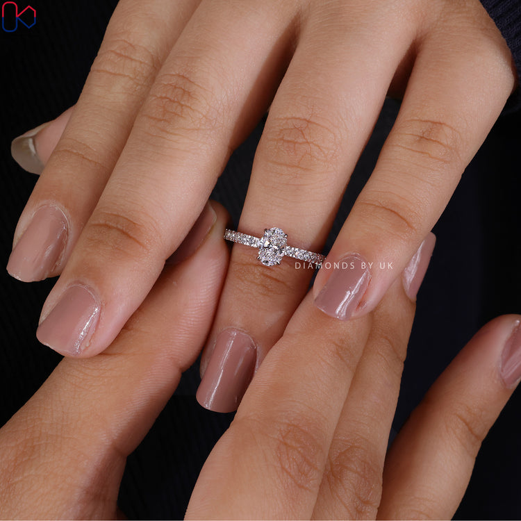 Custom white gold ring with oval and round diamonds.