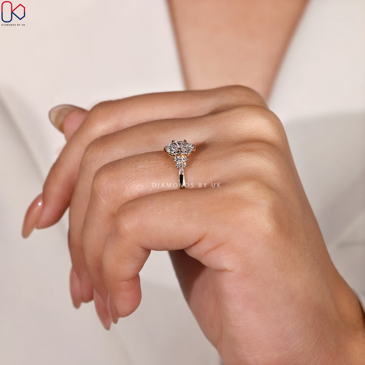 Diamondsbyuk ring with oval diamond and round side stones.
