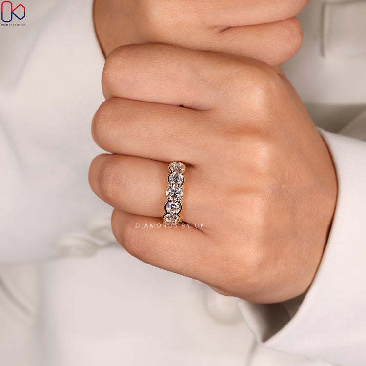 Stunning bezel wedding band showcasing sleek and secure diamond settings.
