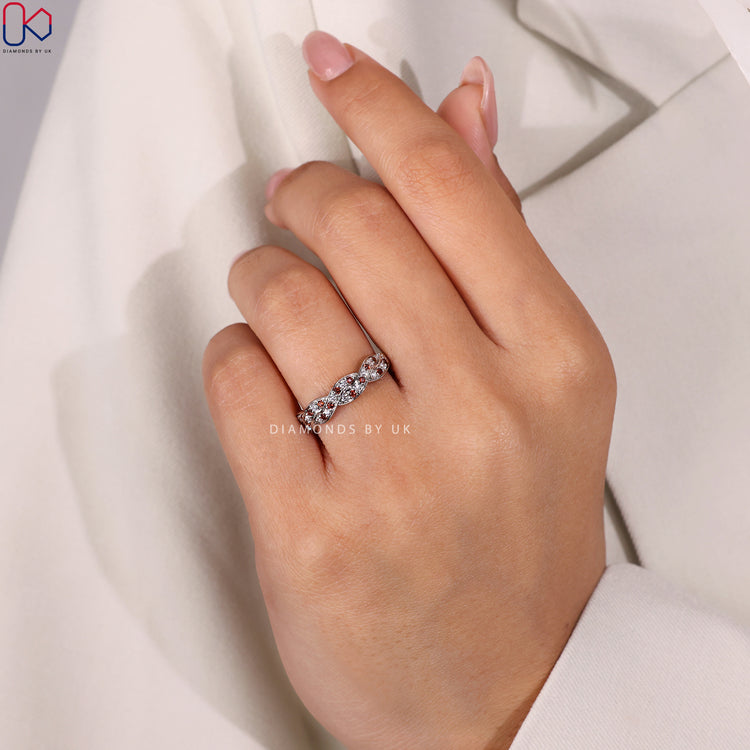 Minimalist wedding band with a twisted design and delicate diamonds.
