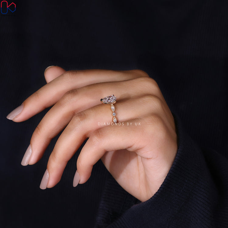 Lab grown diamond ring with round center and marquise frame.
