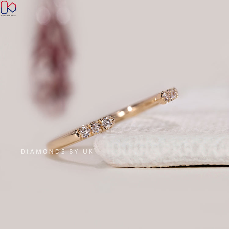 Prong setting band with open gap design and round cut diamonds.
