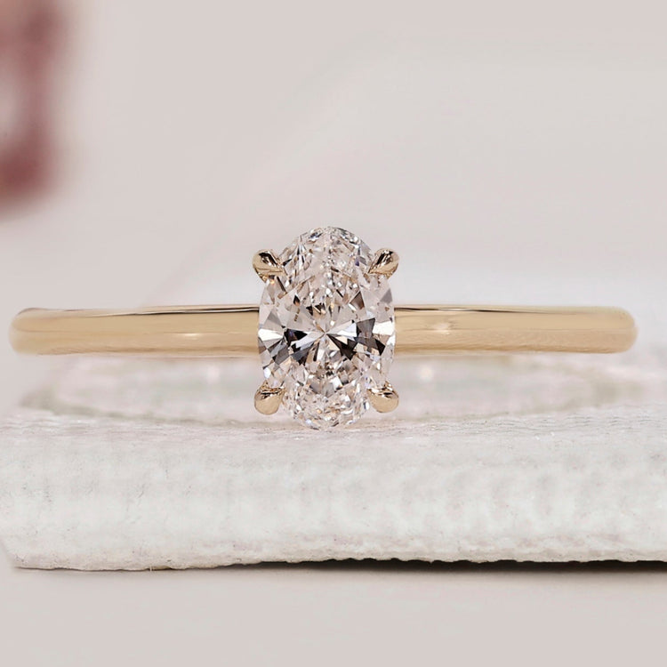 Solitaire engagement ring featuring an oval cut diamond.
