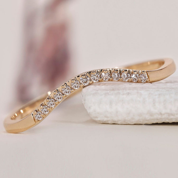 Curved wedding band in yellow gold with a unique design.
