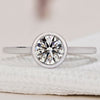 Bezel set engagement ring with a sleek, modern design.
