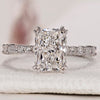 Radiant cut engagement ring with a pave set band.
