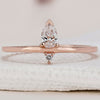 Pear and round wedding band in rose gold with delicate detailing.
