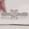 Cushion Cut Diamond Ring with round side diamonds and a twisted pave band, crafted in white gold with a 4 prong claw setting.
