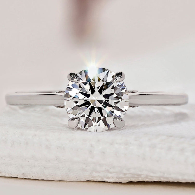 Hidden halo engagement ring with round diamond and white gold.
