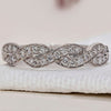 Twisted wedding band with elegant design and sparkling diamonds.
