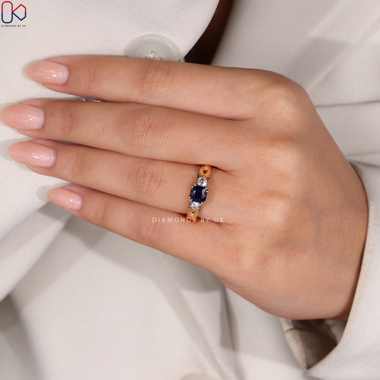 Three stone ring with blue sapphire and round diamonds.
