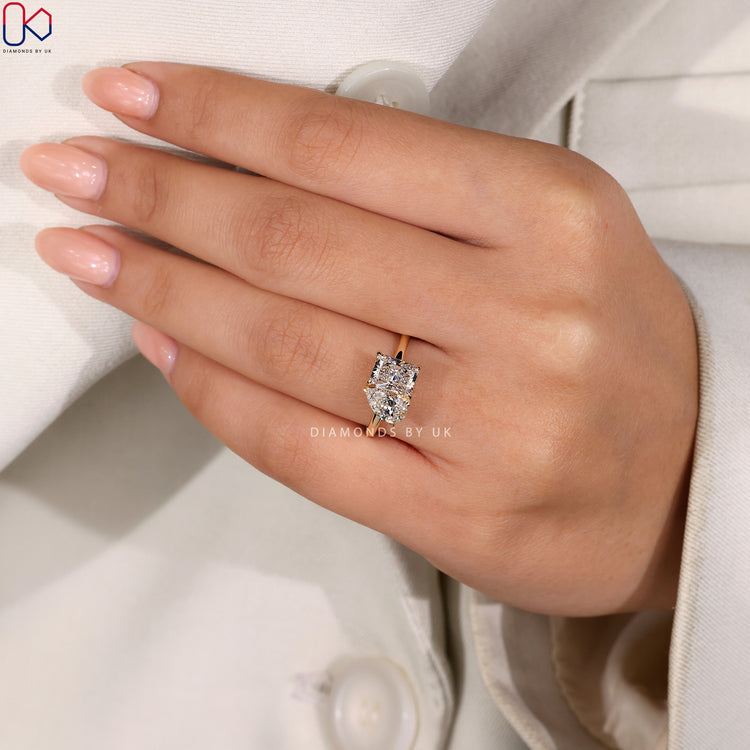 Yellow gold engagement ring with radiant cut diamonds.
