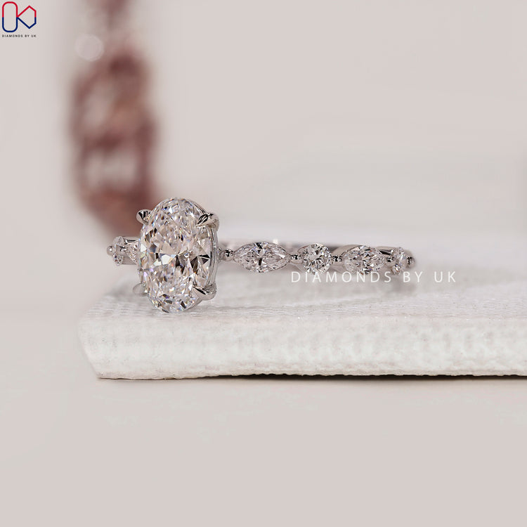 Proposal ring for her with a white gold base and handmade marquise-round side detail.