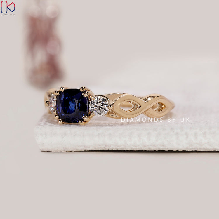 Round cut side stone engagement ring with sapphire.
