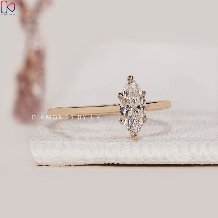 Elegant yellow gold diamond ring with a marquise cut center.

