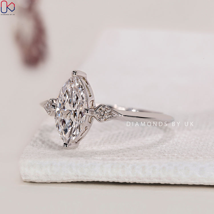 Trilogy Ring with marquise and round diamonds, set in a white gold band.
