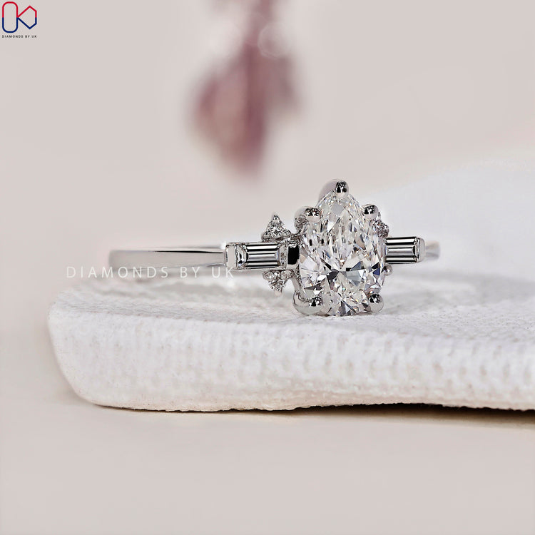 Handmade ring with a tear drop diamond and baguette side stones for added elegance.