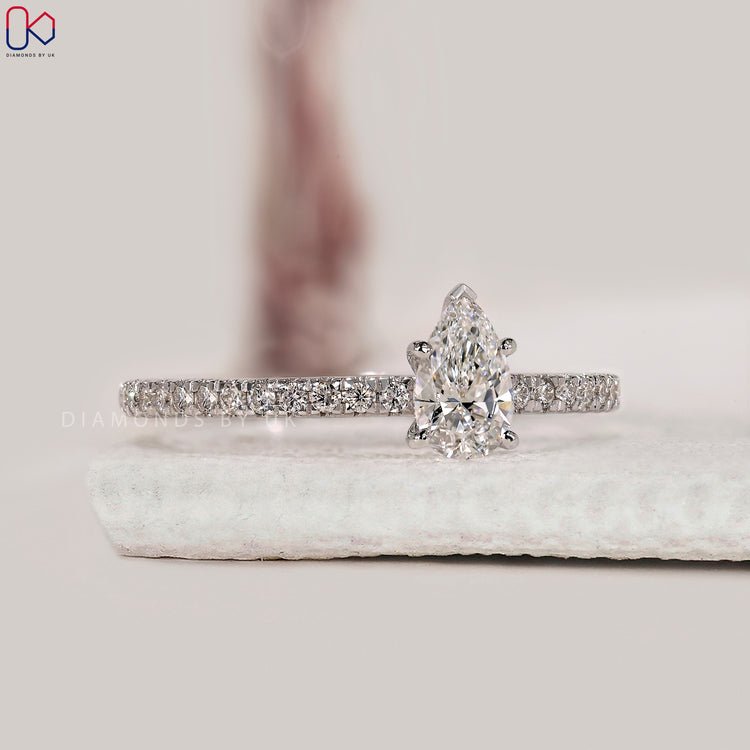 Round cut pave band ring with pear centre stone.
