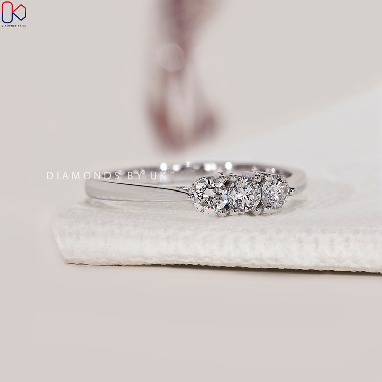 Prong set wedding band with three round diamonds.
