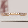 Open gap wedding band with round cut diamonds in yellow gold.
