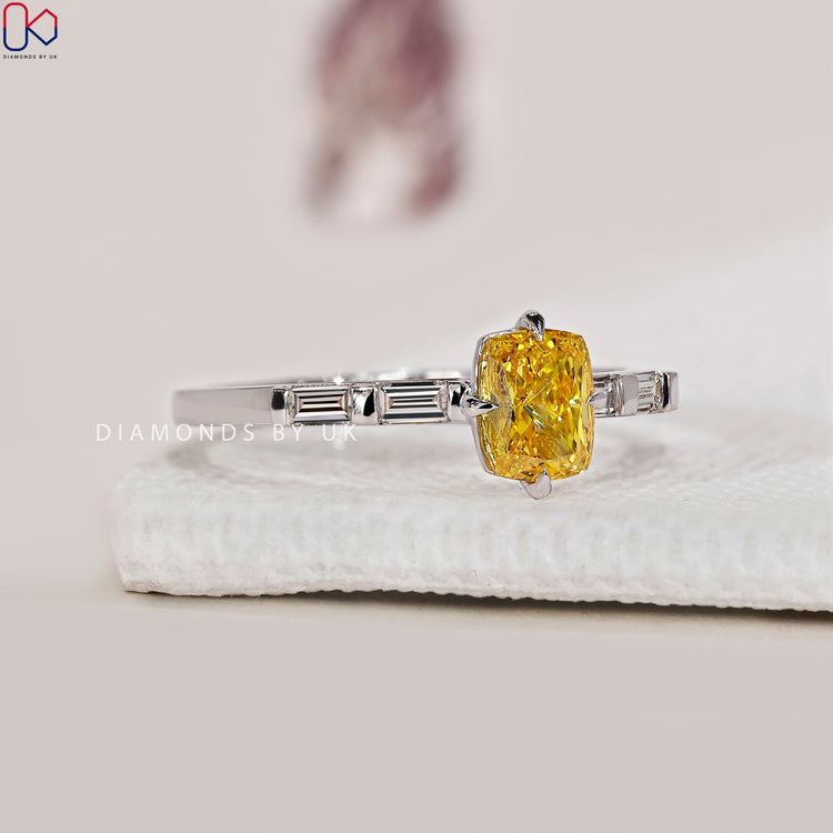 Baguette side stone ring featuring a yellow diamond.
