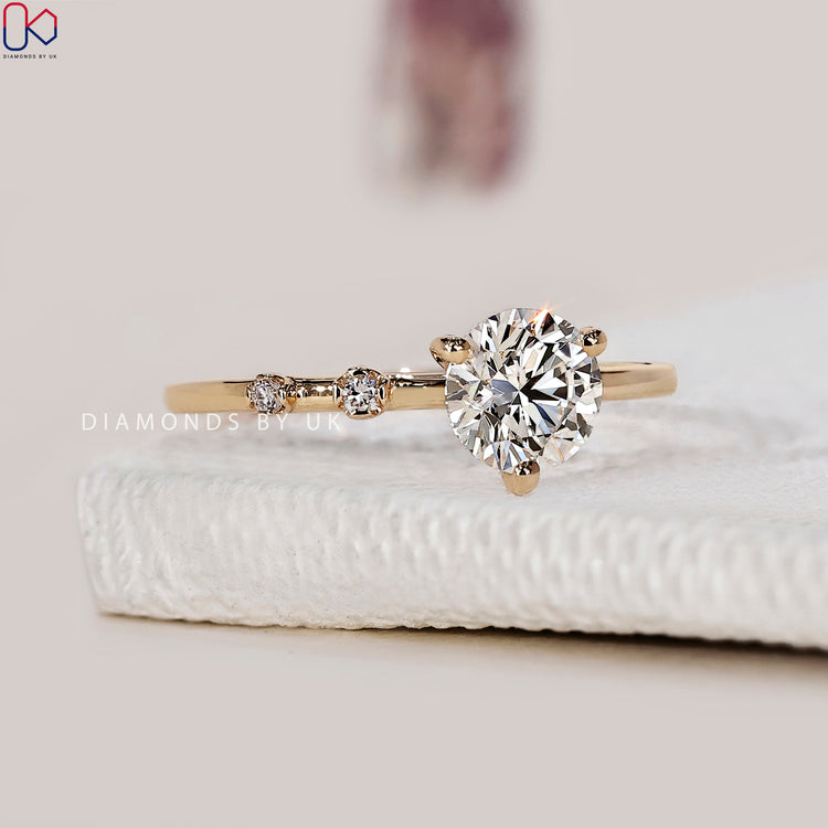 Round side stone engagement ring crafted with Lab Grown Diamond brilliance.
