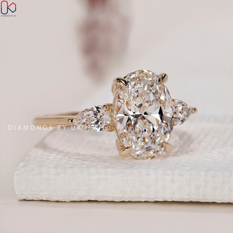 Yellow gold engagement ring with a 3 stone diamond engagement ring featuring oval diamond ring.
