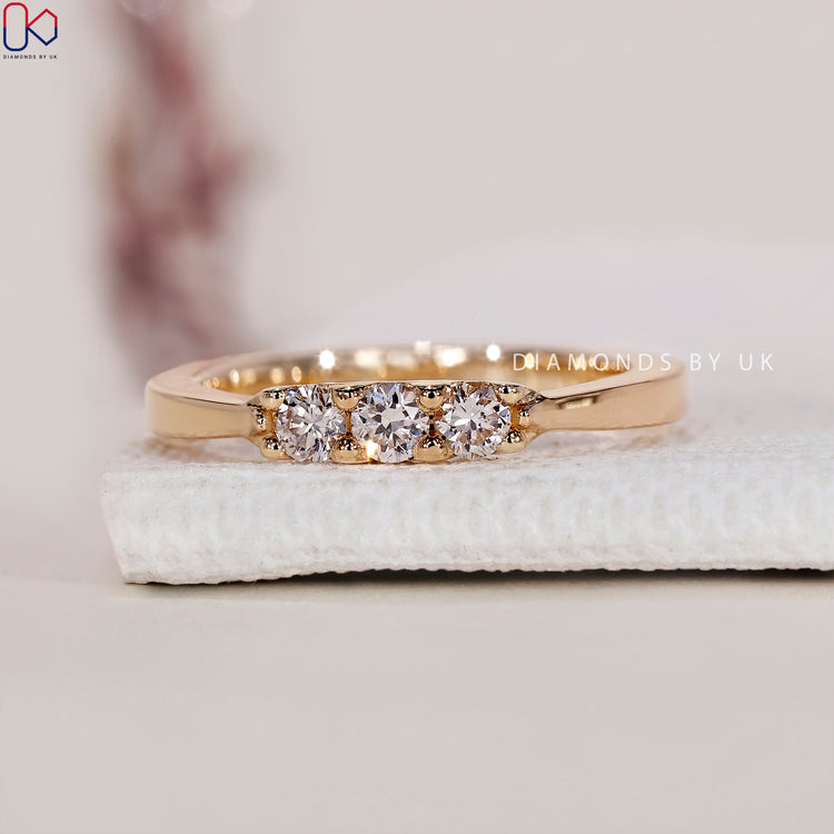 Yellow gold wedding band with three lab grown diamonds.
