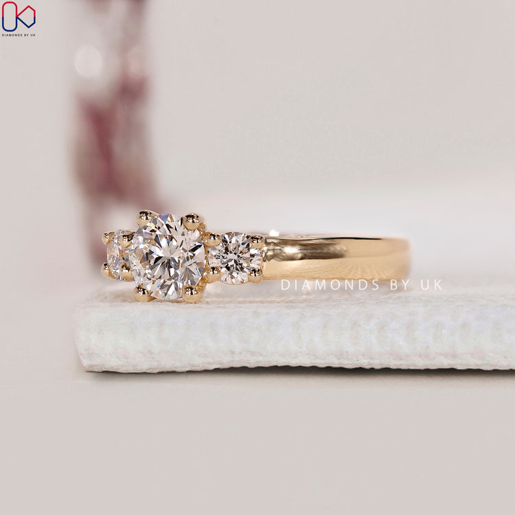 Yellow Gold Engagement Ring with three round diamonds and a prong setting.
