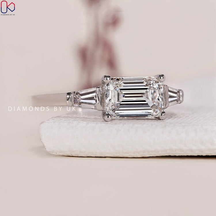 Emerald cut diamond ring with tapered baguettes.
