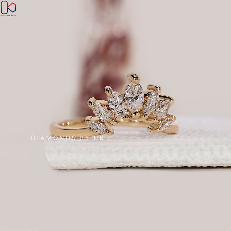 Yellow gold band featuring seven marquise diamonds in a curved style.
