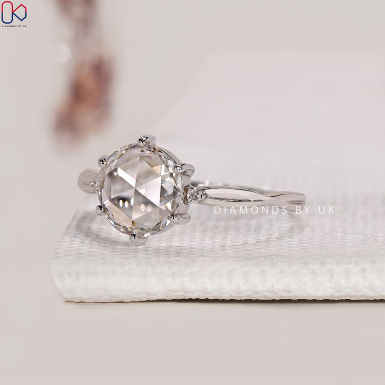 Round side stone engagement ring in white gold.
