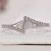 Bypass wedding band with round diamonds in a matte finish white gold design.
