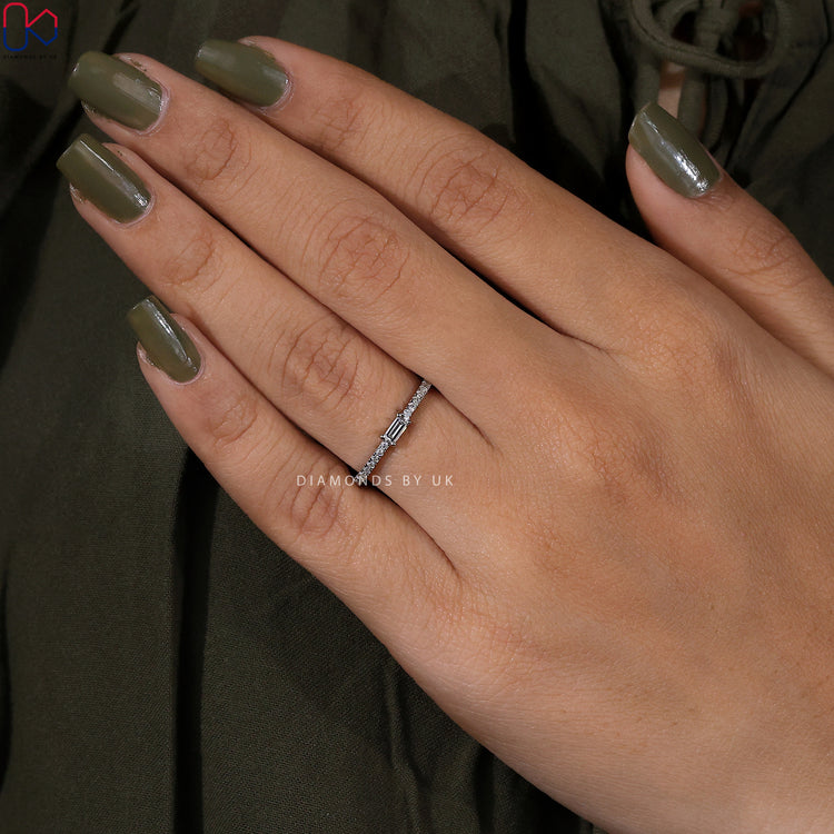 White gold diamond band featuring a baguette centre diamond.
