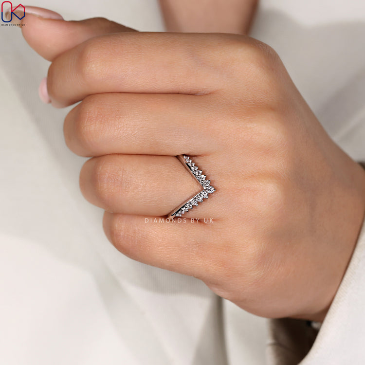 Custom wedding band with round diamonds in a V shaped setting.
