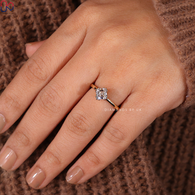 Yellow gold prong setting ring featuring an asscher cut diamond.

