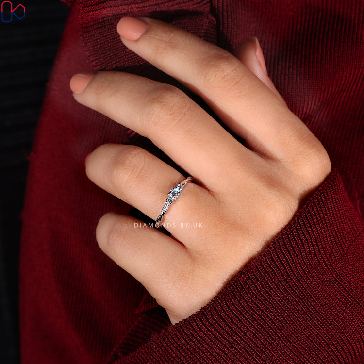 Handmade ring with a twist shank design and three round diamonds.
