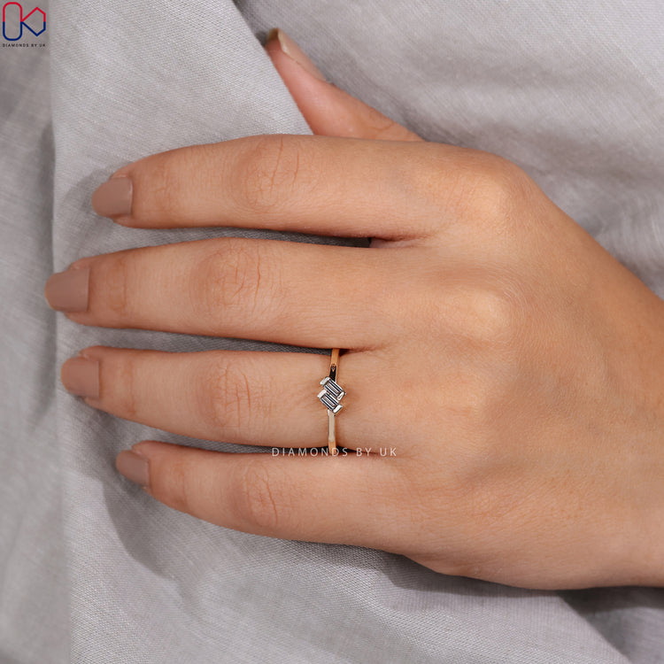 Diamondsbyuk Ring with two baguette diamonds, set in a yellow gold band.
