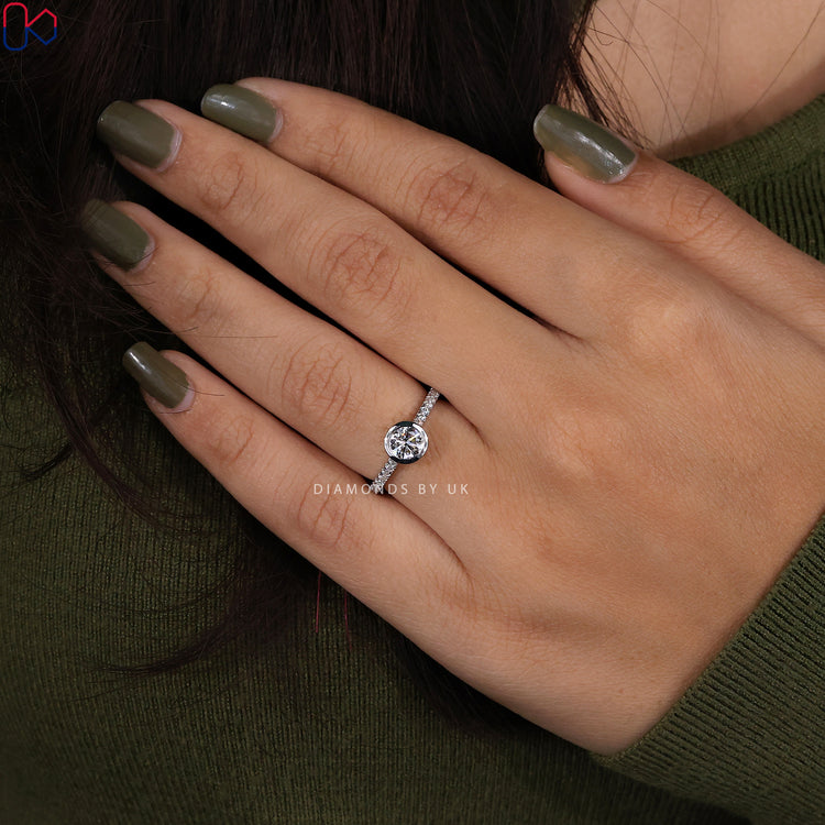 Round cut diamond ring in white gold bezel setting.
