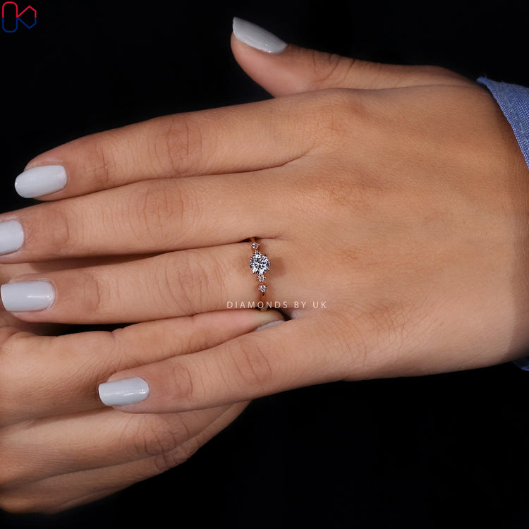 Elegant engagement ring with five round cut diamonds.
