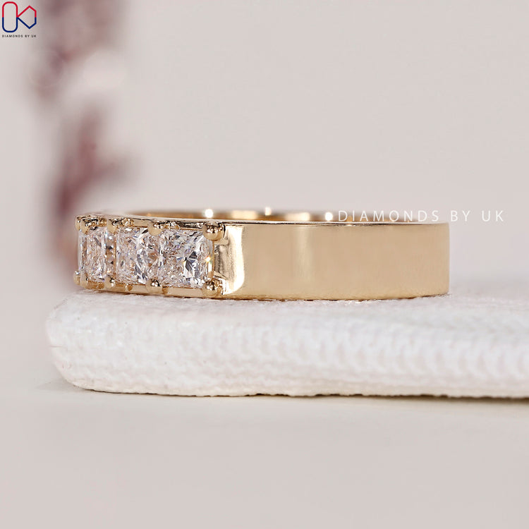 Yellow gold band featuring princess cut diamonds for a luxurious look.
