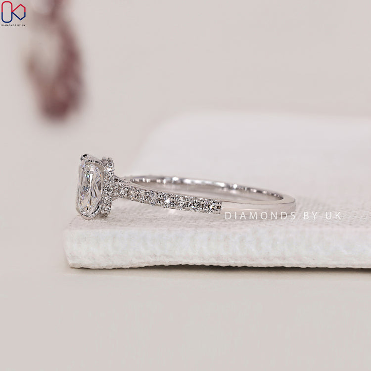 Pave Band Setting with a cushion diamond center and hidden halo, accented with round side diamonds in a cathedral setting.
