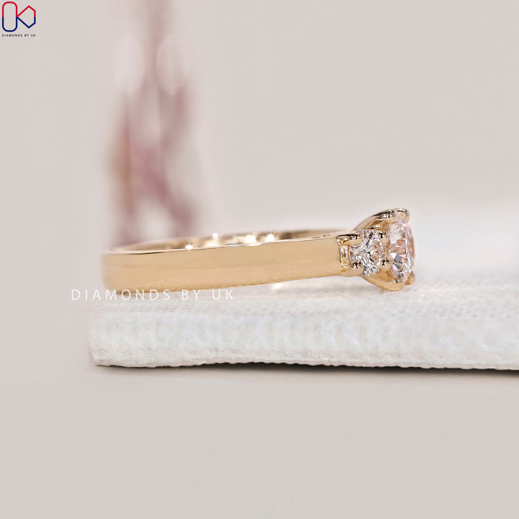 Diamondsbyuk Engagement Ring with round cut diamonds and a yellow gold band.
